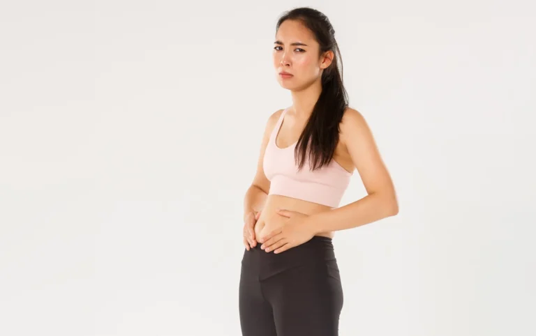 full length upset gloomy asian fitness girl trying lose weight touching belly cant see res